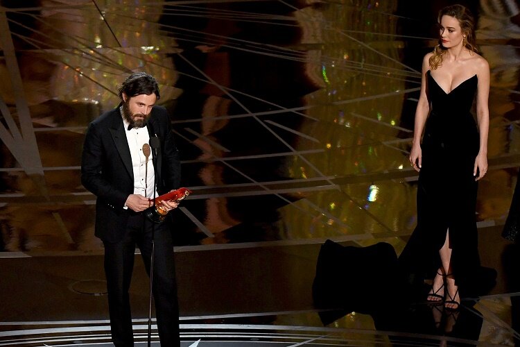 US actor Casey Affleck (L) delivers a speech on stage next to actress Brie Larson (2ndR) after he won the Best Actor award in "Manchester By The Sea" at the 89th Oscars on February 26, 2017 in Hollywood, California. / AFP / Mark RALSTON (Photo credit should read MARK RALSTON/AFP/Getty Images)
